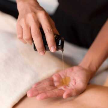 Hand,pouring,oil,for,massage,in,spa